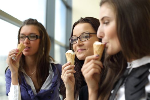 women on foreground licking ice cream 