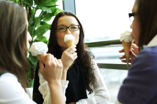 happy smiling women on foreground licking ice cream 