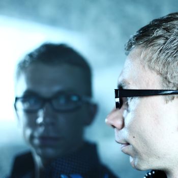 man and his reflection in glass