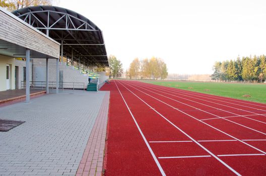Athletics stadium with running tracks and stands and football pitch in middle