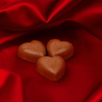 candy hearts on red satin background