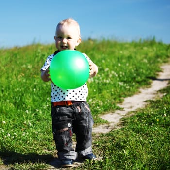  little boy play in green grass with green ball