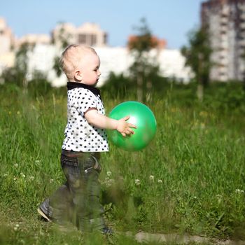  little boy play in green grass with green ball