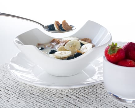 Breakfast of blueberries, bran flakes strawberries with banana