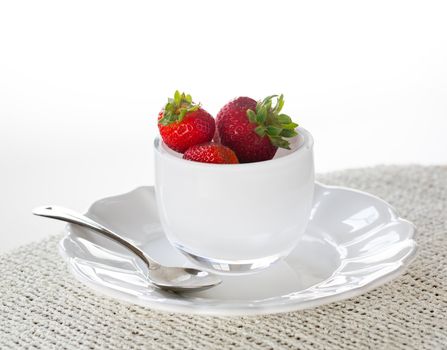 Breakfast of strawberries in glass bowl on white plate