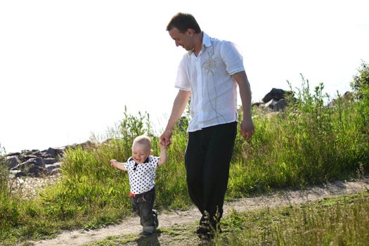 father and son walking on grass