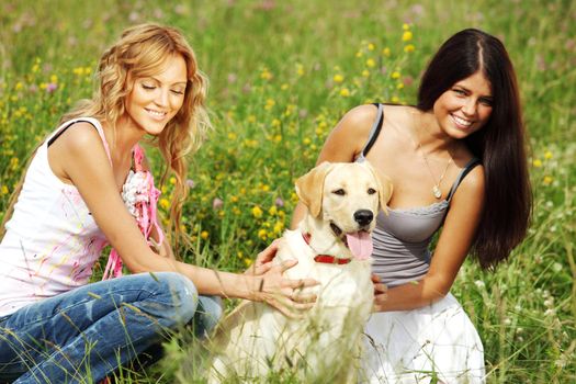 girlfriends and dog in green grass field