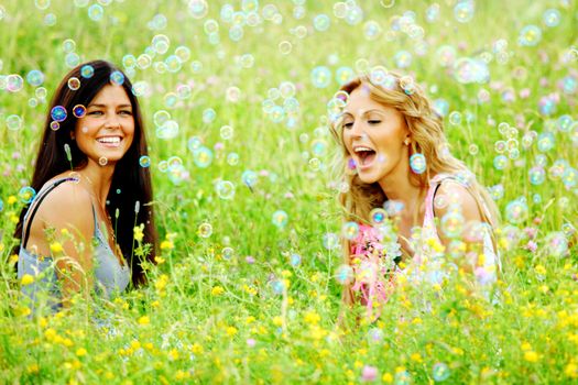 girlfriends on green grass field in soap bubbles