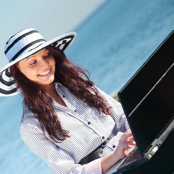 woman with laptop sea background