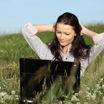 girl with laptop on green grass