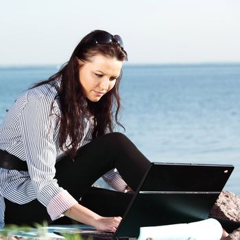 woman with laptop sea background