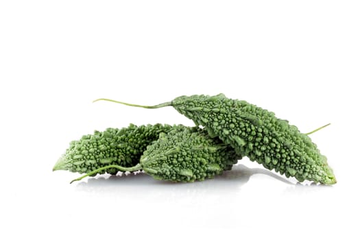 Three bittergourds on white background with shadkows.