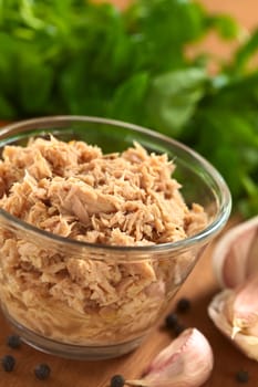 Tuna in glass bowl with garlic cloves, black pepper corns and watercress (Selective Focus, Focus one third into the tuna)