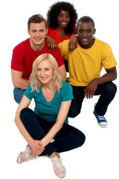 Group of friends sitting on floor and smiling at camera