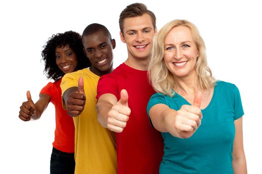 Smiling group of people with thumbs up gesture showing to camera