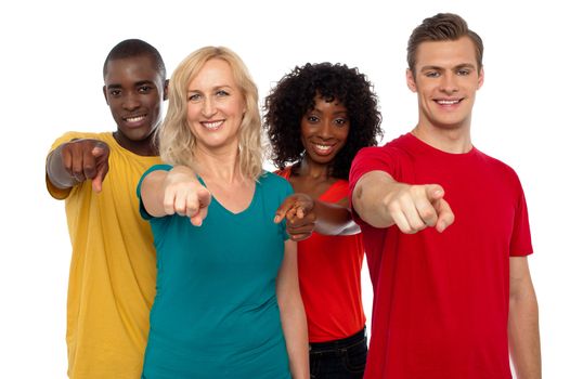 Team of smiling teenagers indicating at you isolated over white background