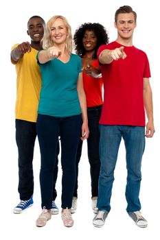 Cheerful group of teenagers pointing at you, full length shot