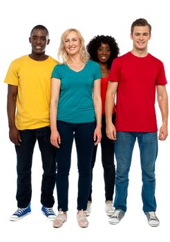 Full length portrait of causal young four friends posing in front of camera