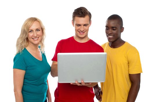 Cheerful group of friends working on laptop isolated over white
