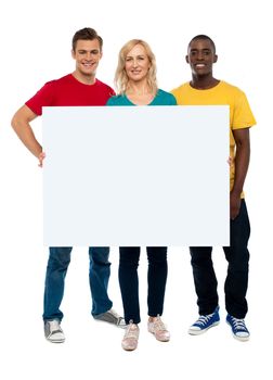 Caucasian young woman showing white adverting board while two guys standing beside her