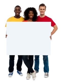 Smiling teenagers presenting blank billboard and looking at camera