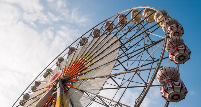 ferris wheel against a blue sky and cloud