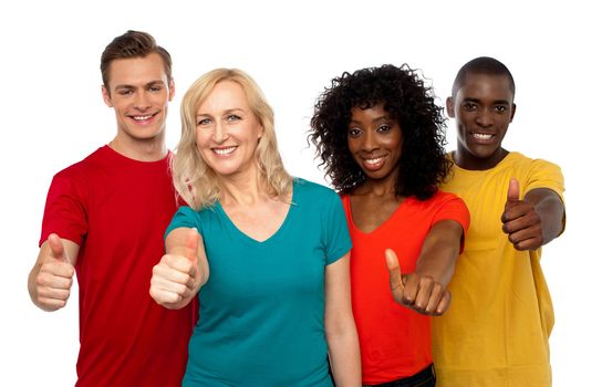 Smiling team of young people showing thumbs up isolated over white background