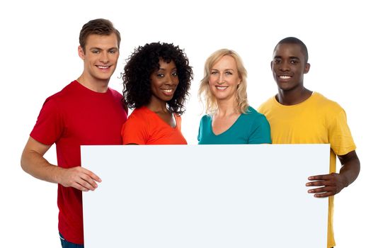 Group of youth displaying blank advertise board and smiling at camera