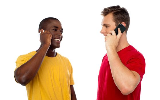 Cool guys communicating via cellphone, looking at each other. All on white background