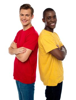 Friends posing back to back with arms crossed isolated on white