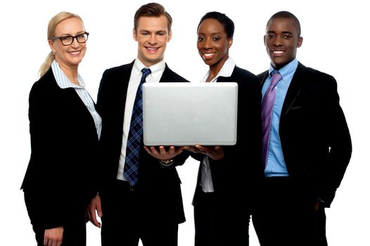 Business colleagues watching video on laptop and posing for camera