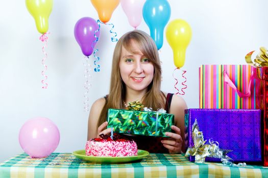 Birthday. An attractive young girl with a gift and cake