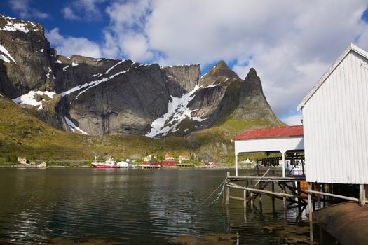 Fishing port in picturesque town of Reine on Lofoten islands, Norway, surrounded by rocky cliffs