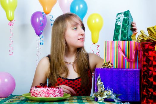 Birthday. An attractive young girl with a gift and cake