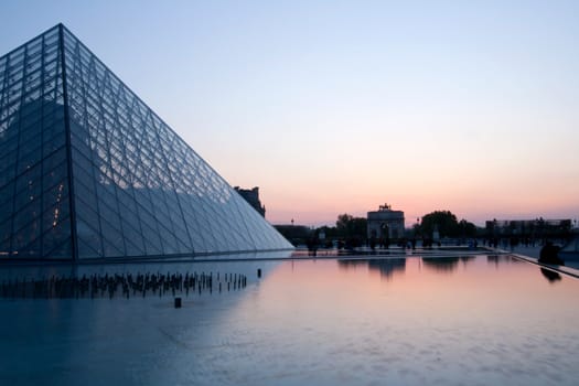 PARIS - APRIL 16: Louvre Pyramid at dusk during the Summer Exhibition April 16, 2010 in Paris. Louvre is the biggest Museum in Paris displayed over 60,000 square meters of exhibition space.