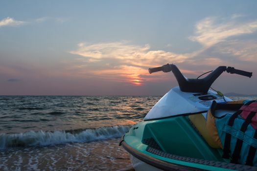 Jetski parked on a beach against blue sky and sunset