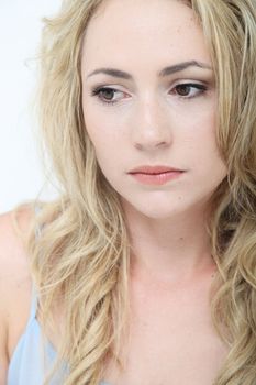 Beautiful sad young woman with a wistful expression lost in thought , closeup studio headshot on white 