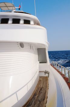 Deck of big wooden marine yacht with portholes and deck cabin in the sea.