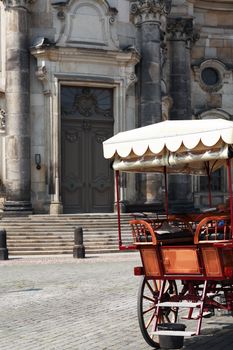 Closeup of vintage wooden carriage near gray old building