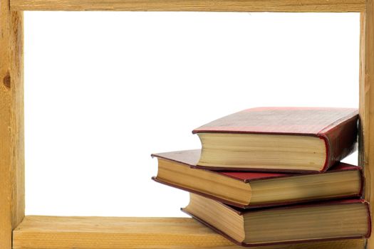Some books with hard dark red covers in a wooden frame on white background