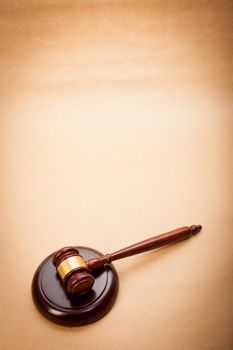 A wooden gavel and soundboard on a light brown background.