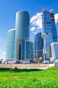Construction of new skyscrapesrs and green grass 