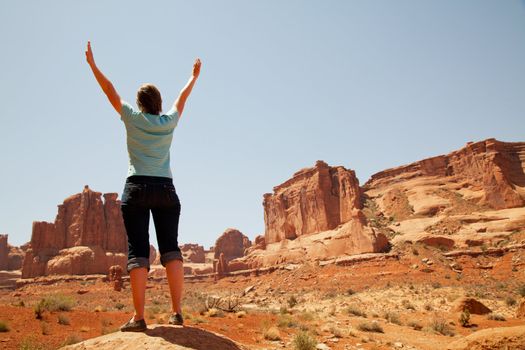 Woman with raised hands staying at Arches National Park, Utah