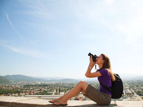 Young lady photographer shooting outdoors 