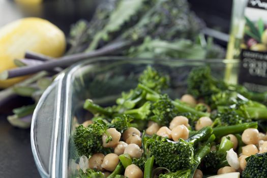 Broccoli  and chick peas in a baking dish ready to be cooked.