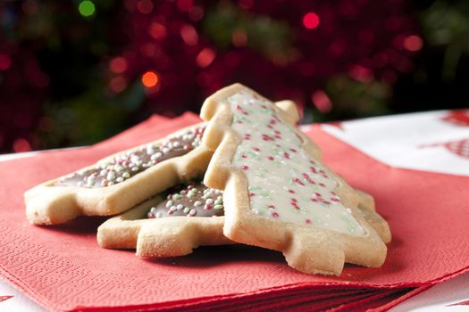 Tree shaped Christmas cookies on a red napkin.
