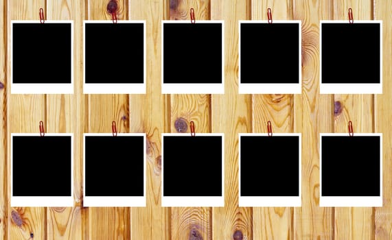 set of ten old blank polaroids frames lying on a wood surface 