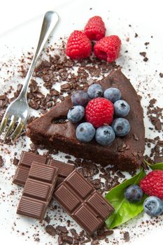 Piece of chocolate cake with fresh berry on white background 