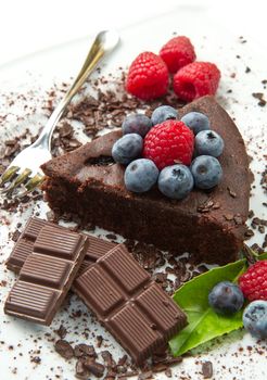 Piece of chocolate cake with fresh berry on white background 