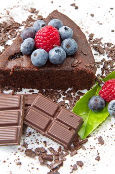 Piece of chocolate cake with fresh berry on white background 